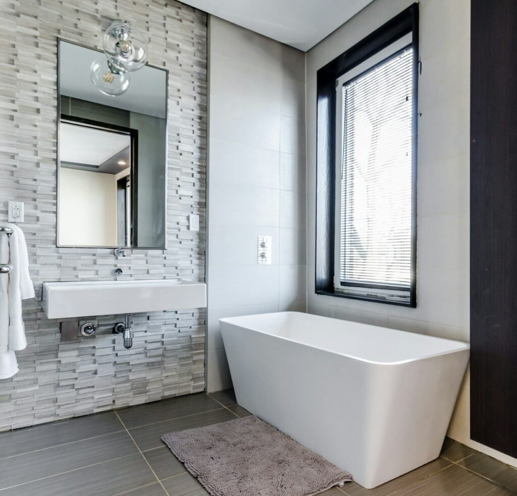 Bathroom with a stone tile accent wall and a freestanding tub