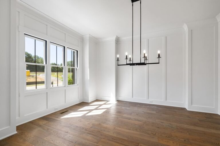 Dining room with a black chandelier and tall windows