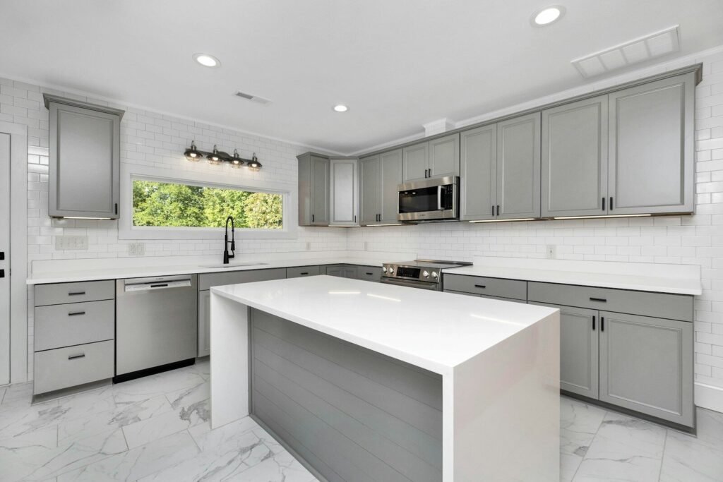Gray cabinet kitchen with a white quartz island