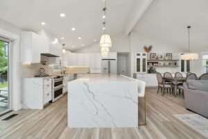 Open-concept kitchen with a marble island flowing into the dining area