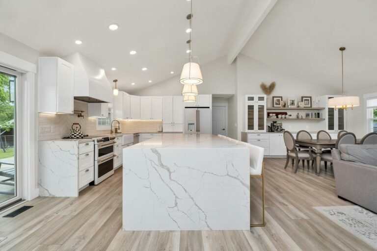 Open-concept kitchen with a marble island flowing into the dining area
