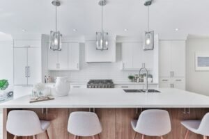 White kitchen with a wood island and three pendant lights