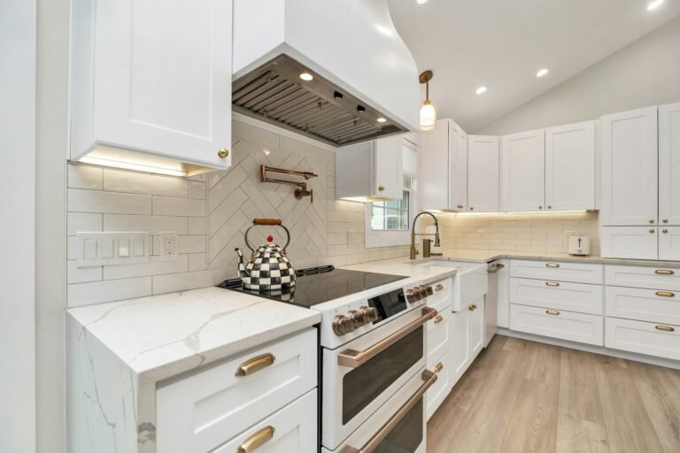 White shaker kitchen with quartz counters and a stainless range