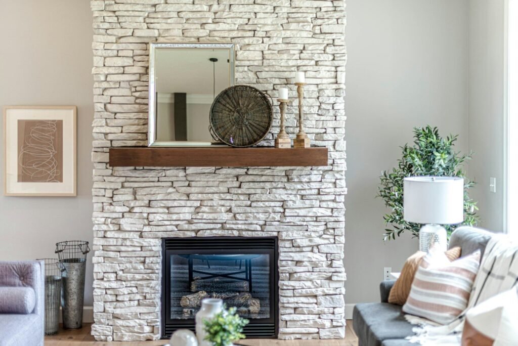 Living room with a stacked stone fireplace and wood mantel