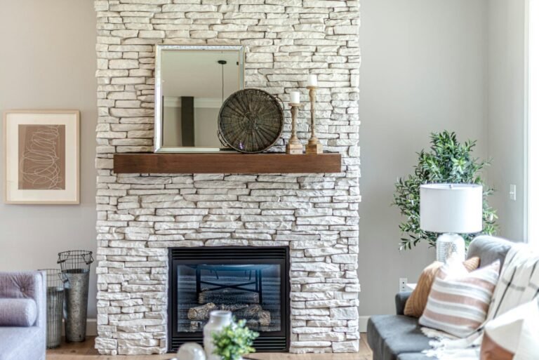 Living room with a stacked stone fireplace and wood mantel