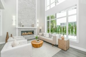 Two-story great room with a stone fireplace and tall windows