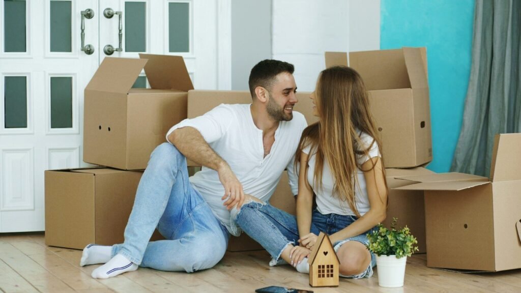 Couple relaxing among moving boxes in their new home